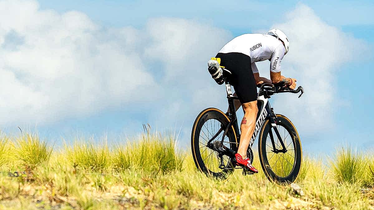 A Male Cyclist Rides A Time Trial Bike On A Road