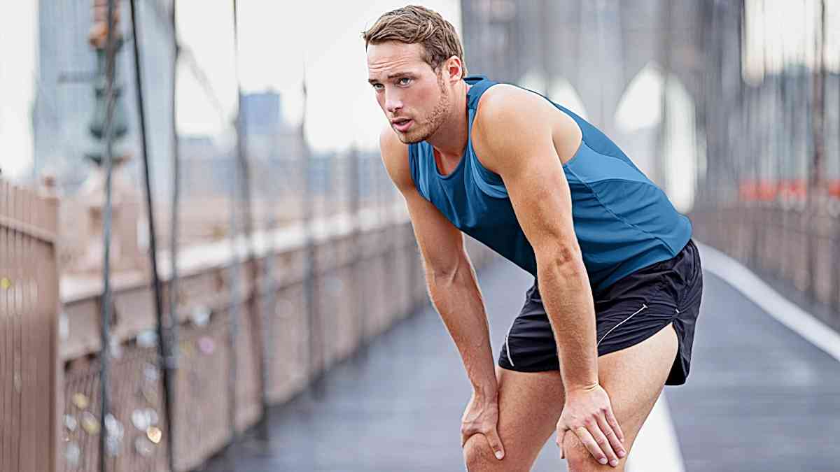 Finding The Right Running Zones Image Of A Male Runner Taking A Break From Jogging Down Road Training In The Right Running Zone