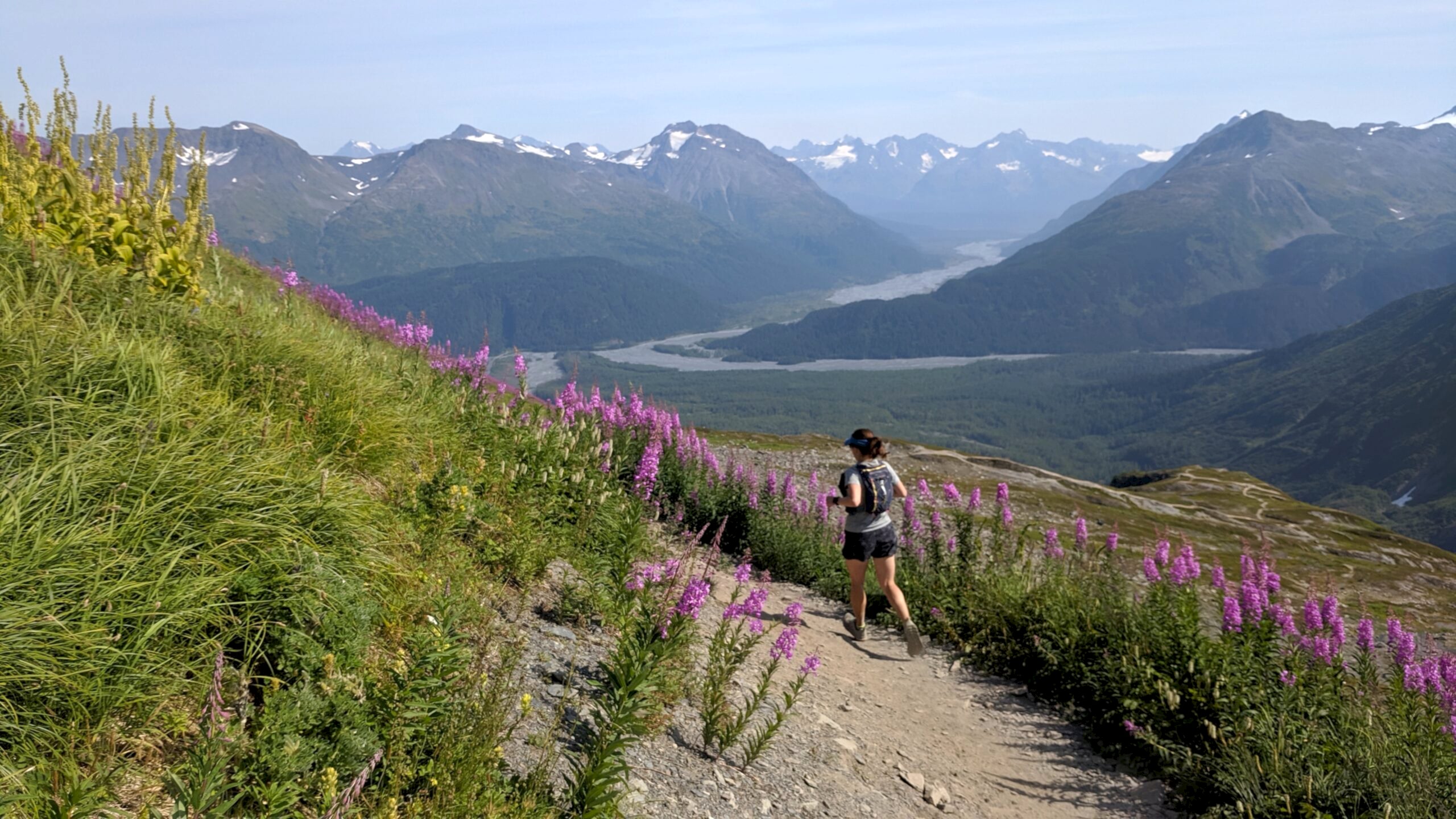 Ultrarunning From Triathlon A Female Runner On A Trail Above A Deep Valley With Flowers Lining The Trail