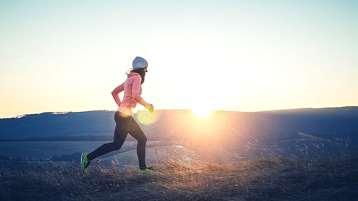 Base Training For Runners Image Of A Woman Trail Running In The Early Morning As A Running Base Training Workout