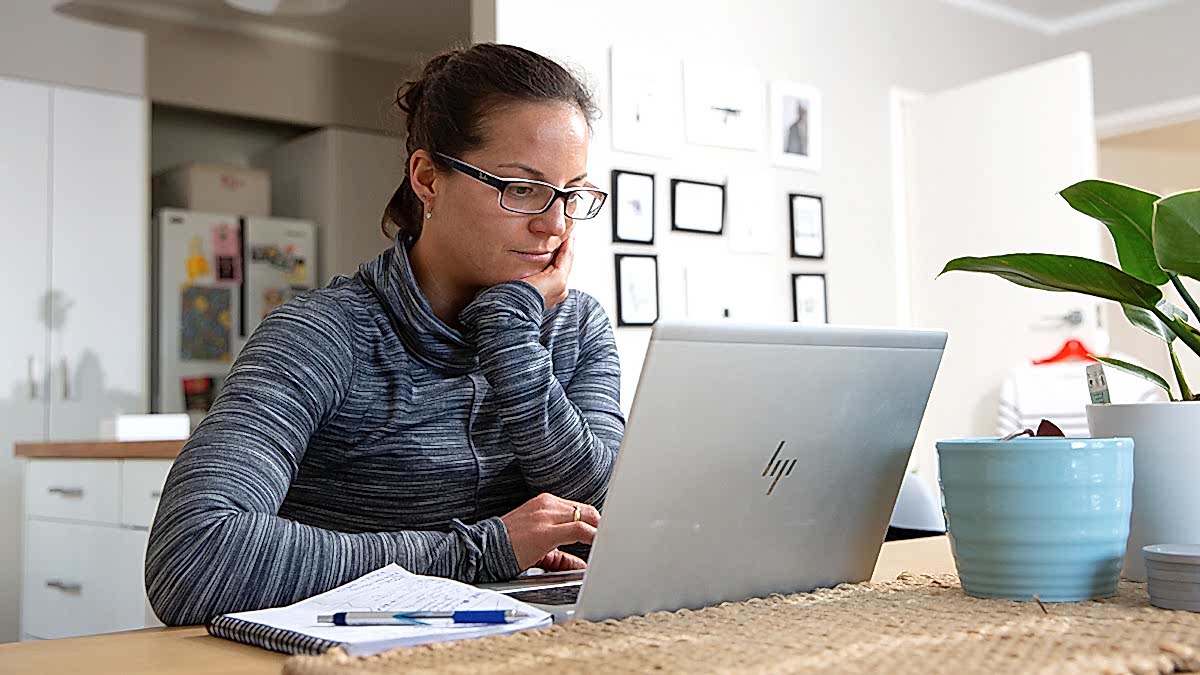Triathlon Coach Woman Sitting At A Desk On A Computer Making Training Plans For Athletes